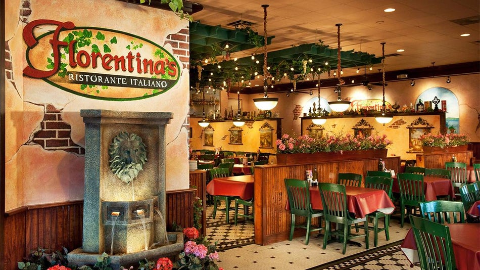 Interior view of Florentina's Ristorante Italiano with red cloth covered tables and green chairs and floral accents plus a fountain with a lions head on it and a sign for the restaurant above it when you first enter in Branson, Missouri, USA
