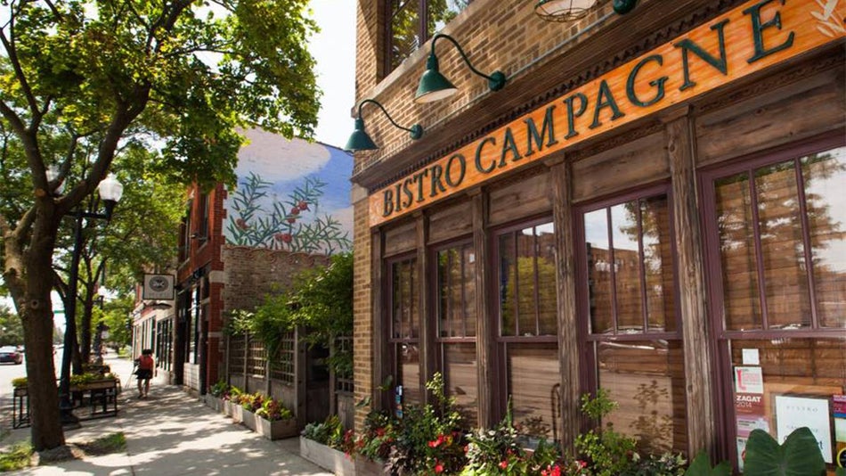 Exterior view of Bistro Campagne with its wooden sign above the windows in Chicago, Illinois, USA