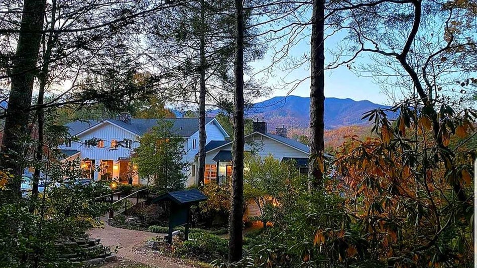 Looking down through the woods at The Buckhorn Inn at dusk with their lights on in Gatlinburg, Tennessee, USA