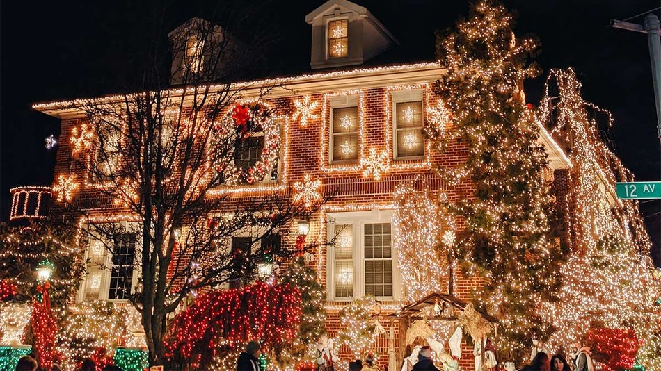 Large house decorated with bright warm colored Christmas lights at night