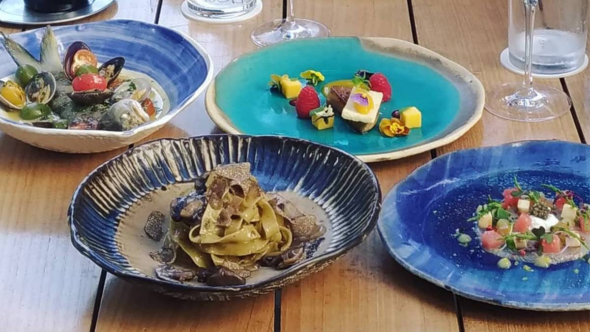 Four signatures dishes from Noe served in blue dishes on a wooden table in Kapolei, Hawaii, USA