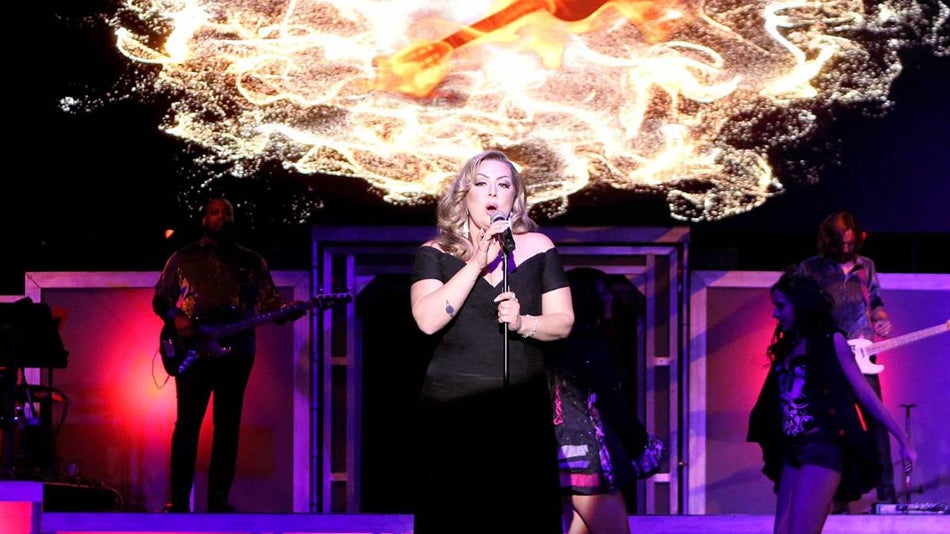 An Adele impersonator performing on stage at Legends in Concert with flames behind her in Las Vegas, Nevada, USA