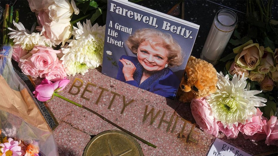 Close up of Betty White's star on the Wall of Fame covered in flowers and a magazine saying "Farewell Betty" in Los Angeles, California, USA