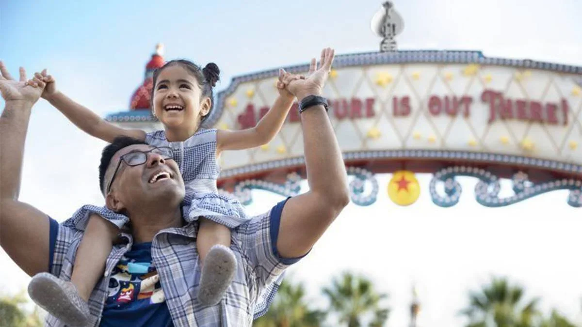 father and daughter in front of disneyland