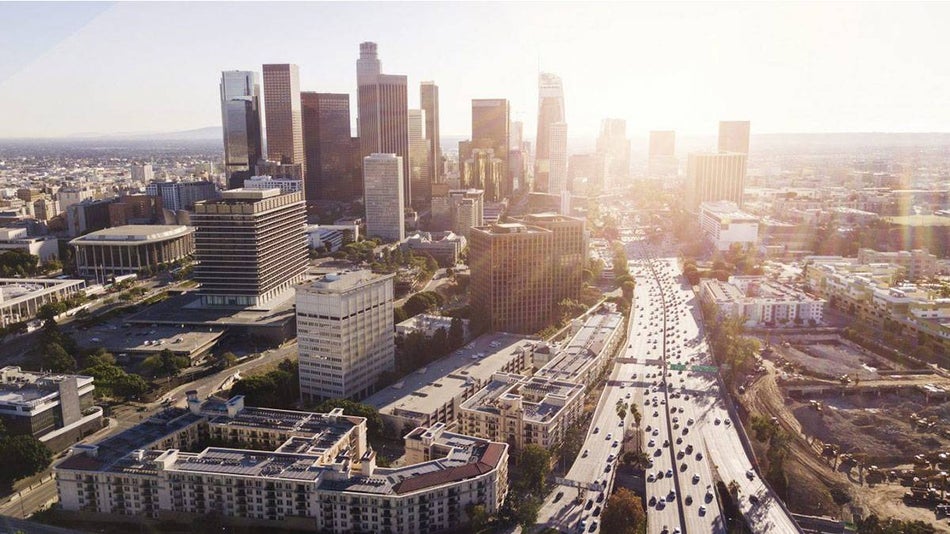 aerial view of cars driving on downtown los angeles freeway during daytime sunlight