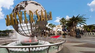 Universal Studios entrance and red carpet with palm trees lining it at Universal Studios Hollywood in Los Angeles, California, USA