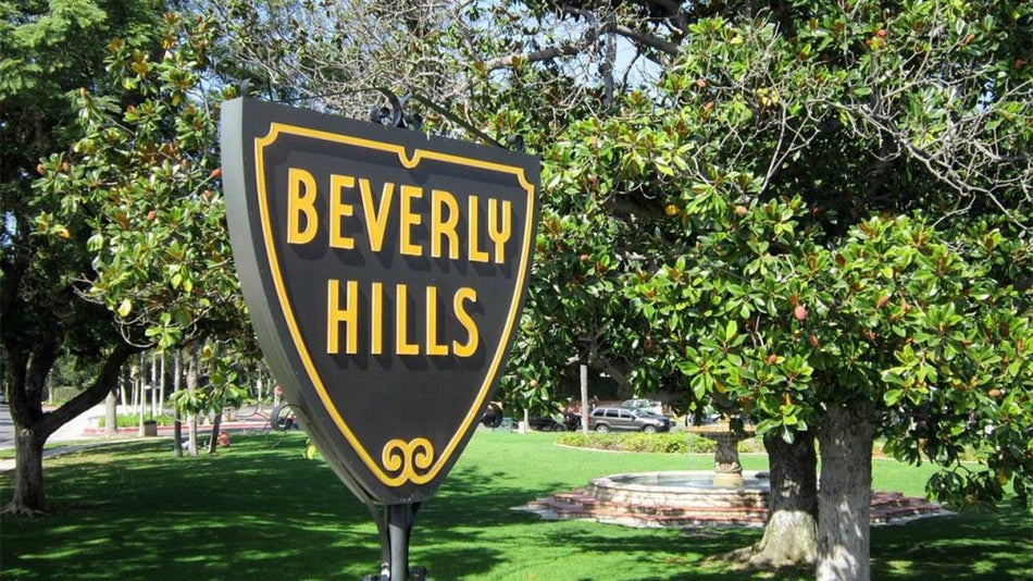 close up of Beverly Hills sign with trees in the background in Los Angeles, California, USA