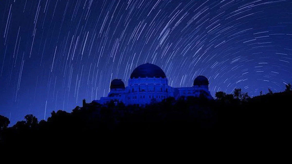 night view of Griffith Observatory with dark blue blurry sky in background in Los Angeles, California USA