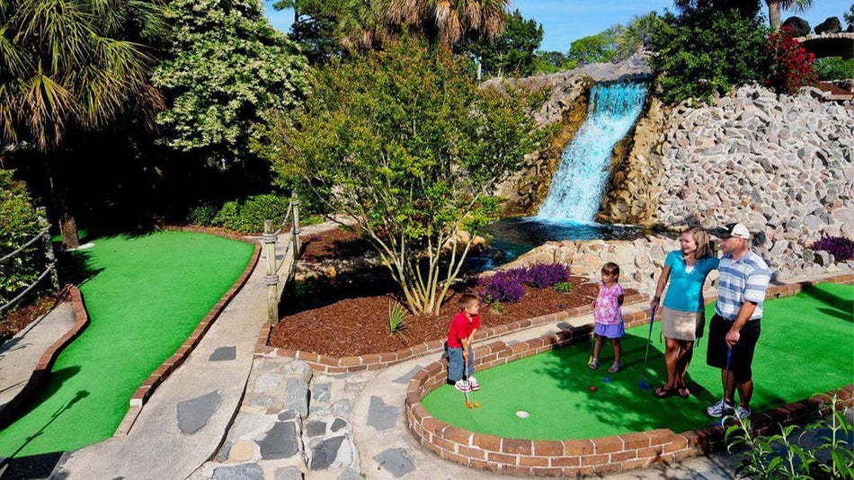 family on mini golf course with waterfall at Jurassic Mini Golf in Myrtle Beach, South Carolina, USA