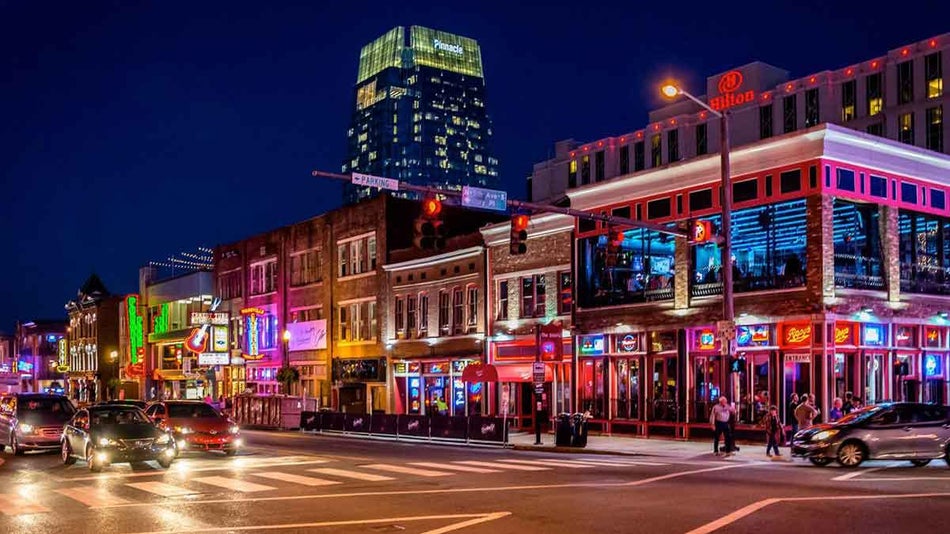 night view of lights on buildings with cars on streets at Broadway in Nashville, Tennessee, USA
