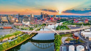 aerial drone view of the Cumberland River and downtown with sun setting in Nashville, Tennessee, USA