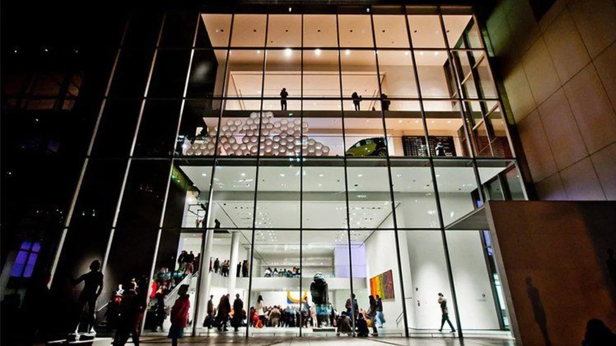 Wide shot of people walking through the Museum of Modern Art in New York City, New York