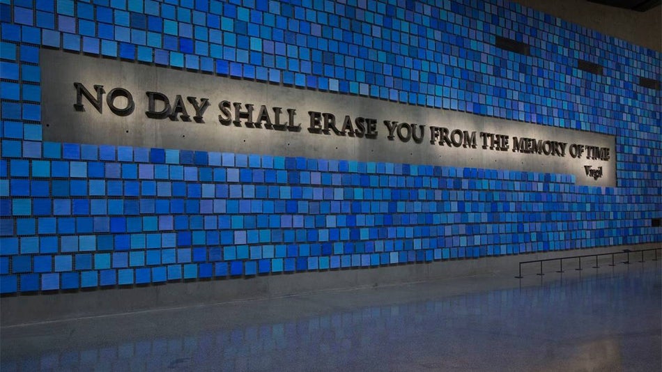 Close up of Trying to Remember the Color of the Sky on That Tuesday Morning, a 9/11 Art Memorial made of concrete and blue tiles with the words "NO DAY SHALL ERASE YOU FROM THE MEMORY OF TIME" in an all caps service font with lights at the National September 11 Memorial & Museum in NYC, New York, USA