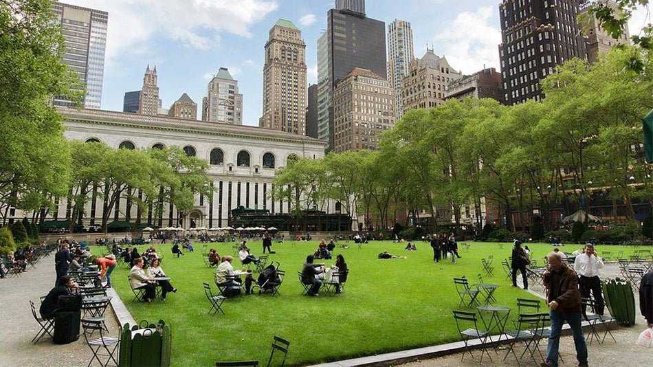 people sitting at tables on grass in Bryant Park in Manhattan NYC, New York, USA