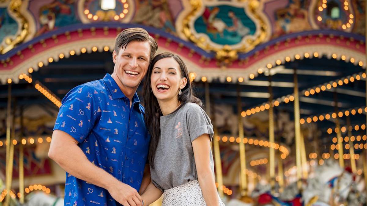 Close up of a couple smiling and standing in front of a carousel at Disney Springs in Orlando, Florida, USA