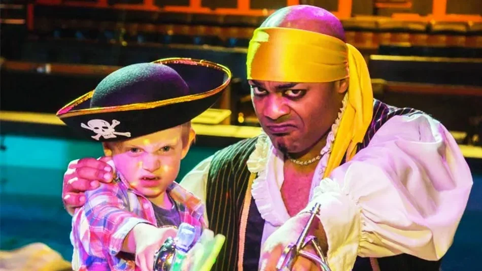 young boy and pirate holding swords together at Pirate’s Dinner Adventure in Orlando, Florida, USA