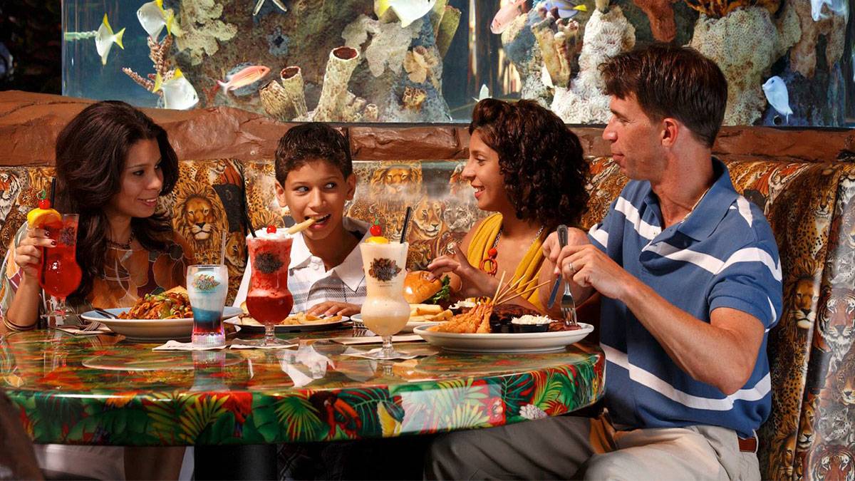 family dining with aquarium in background at Rainforest Cafe in Orlando, Florida, USA