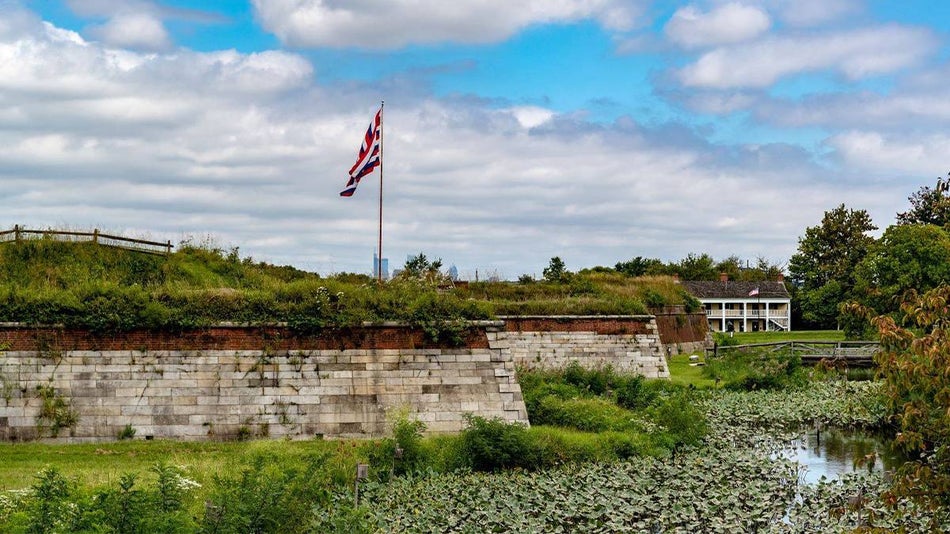 exterior view of fort mifflin on delaware with flag pole and airplane in the sky in Philadelphia, Pennsylvania, USA