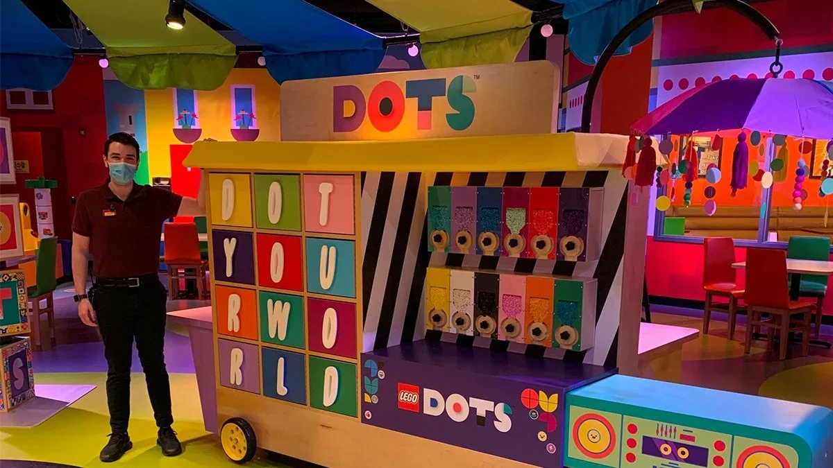 Shot of the LEGO DOTS centers with a male LEGO employee standing next to one of the activities at the LEGOLAND® in Philadelphia, Pennsylvania