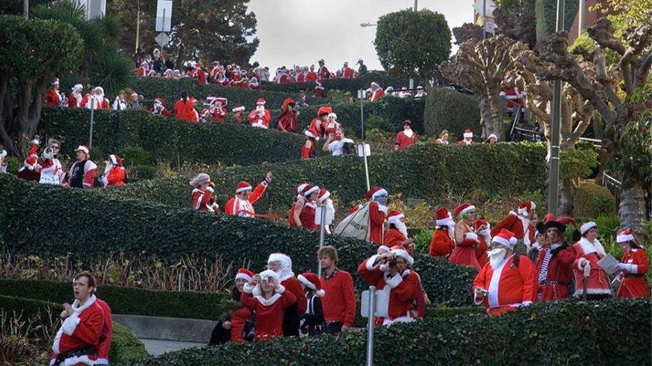 Shot looking up Lombard Street with hundreds of people dressed as Santa walking down it in San Francisco, California, USA