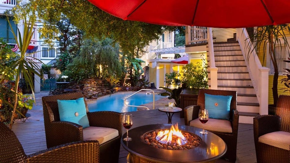 small firepit surrounded by chairs next to an outdoor pool at the Azalea Inn and Villas in Savannah, Georgia