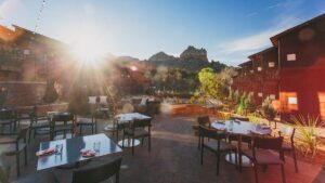 Wide shot of the out door dining area at Salt Rock Kitchen on a sunny day with the rocky Sedona landscape in the background in Sedona, Arizona, USA