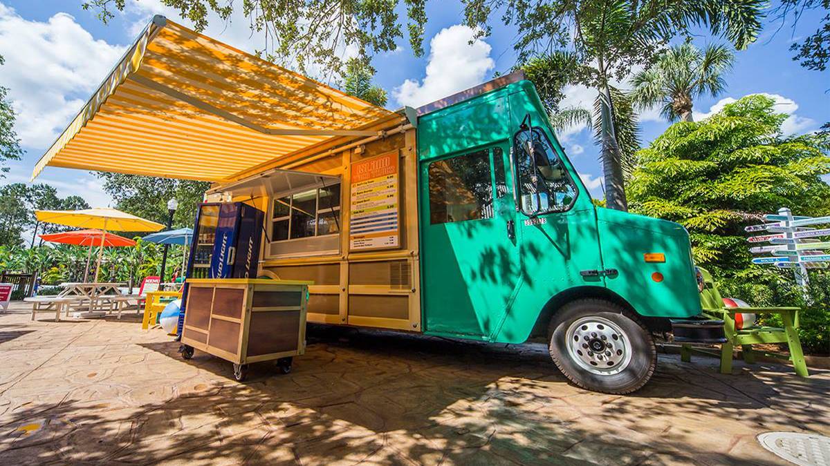 Close up photo of the blue-green and wood Island Food Truck on a sunny day at Adventure Island in Tampa, Florida, USA