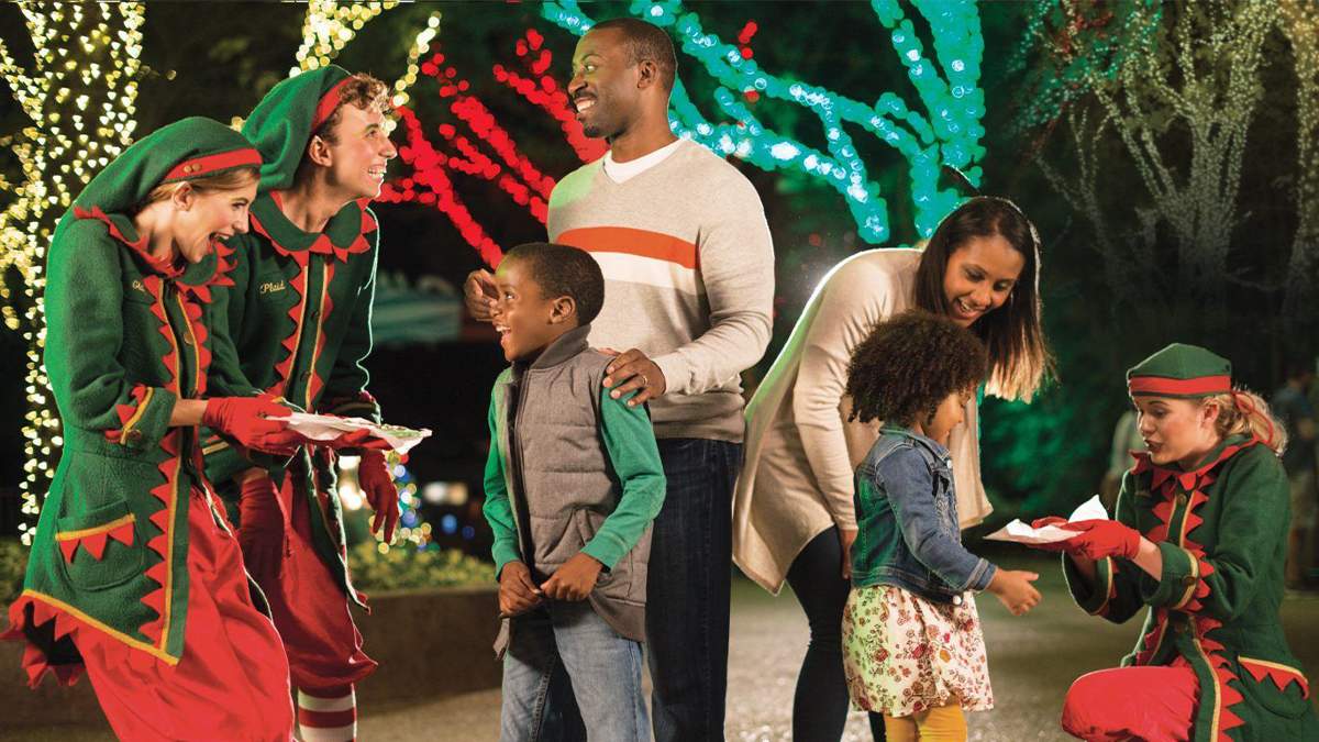 family of kids and parents talking with holiday christmas elves at Busch Gardens in Tampa, Florida, USA