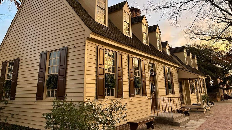 Close up photo of the exterior of Chowning’s Tavern, a White House with black shutters and roof, at sunset in Williamsburg, Virginia, USA