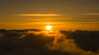 aerial view of bright orange sun over clouds at Haleakalā National Park in Maui, Hawaii, USA