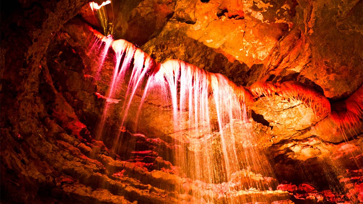 Close up of the orange walls and waterfalls in Marvel Cave at Silver Dollar City in Branson, Missouri, USA