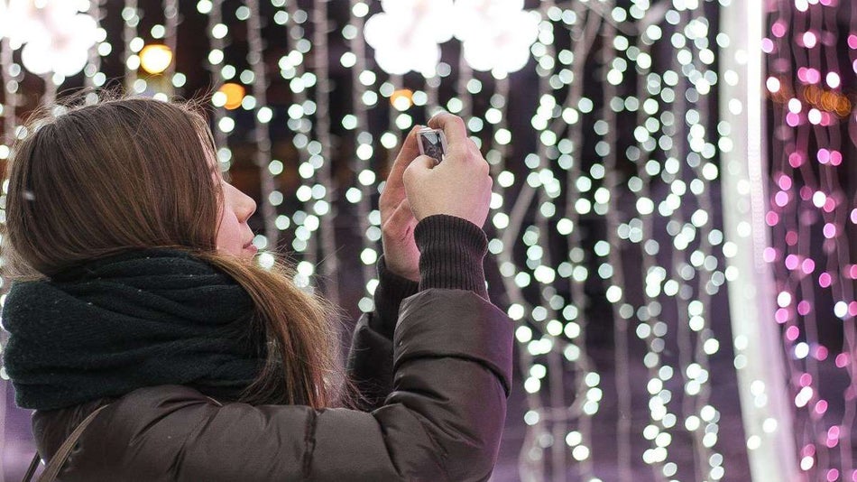 woman taking photo of christmas lights