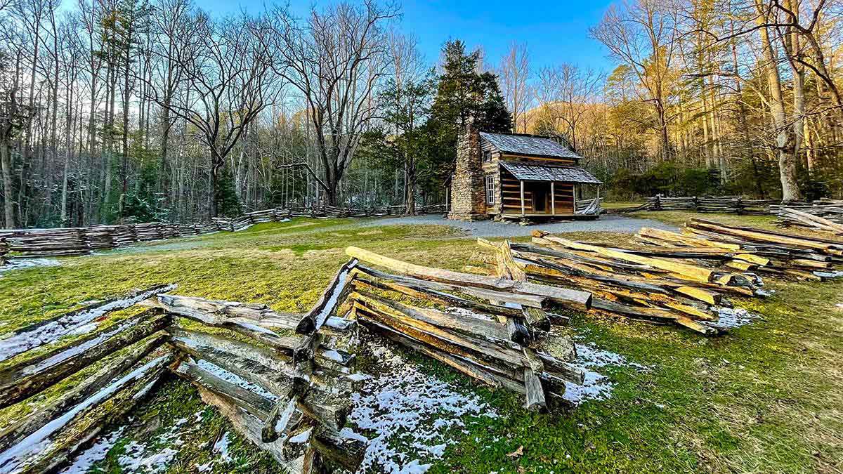 Distant view along a fence with John Oliver Cabin in background Cades Cove in Great Smoky Mountain National Park in Gatlinburg, Tennessee, USA