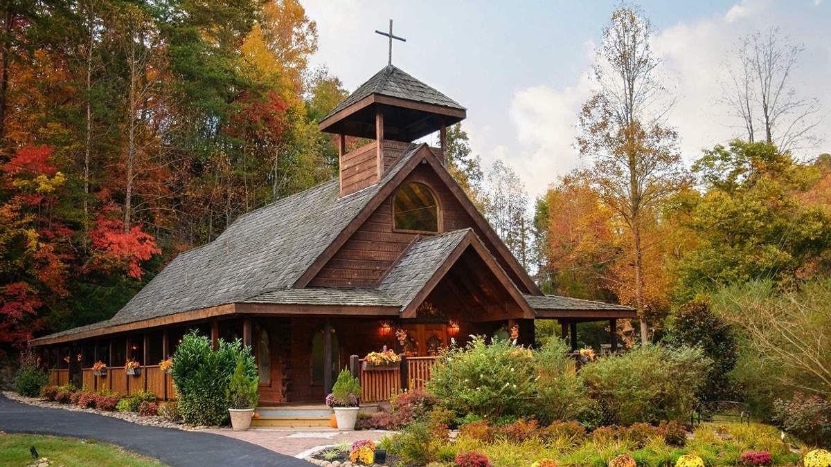Exterior view of wooden chapel in surrounded by fall foliage in the Smoky Mountains