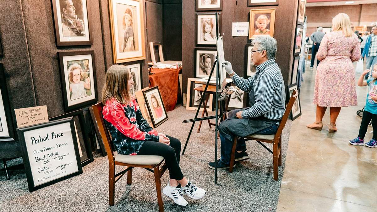 A painter paints a portrait of a child at the Gatlinburg Craftsmen's Fair in Gatlinburg, TN, USA