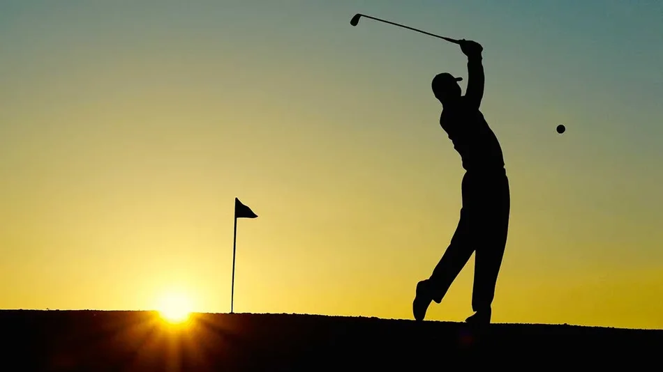 silhouette of golfer on course at sunset