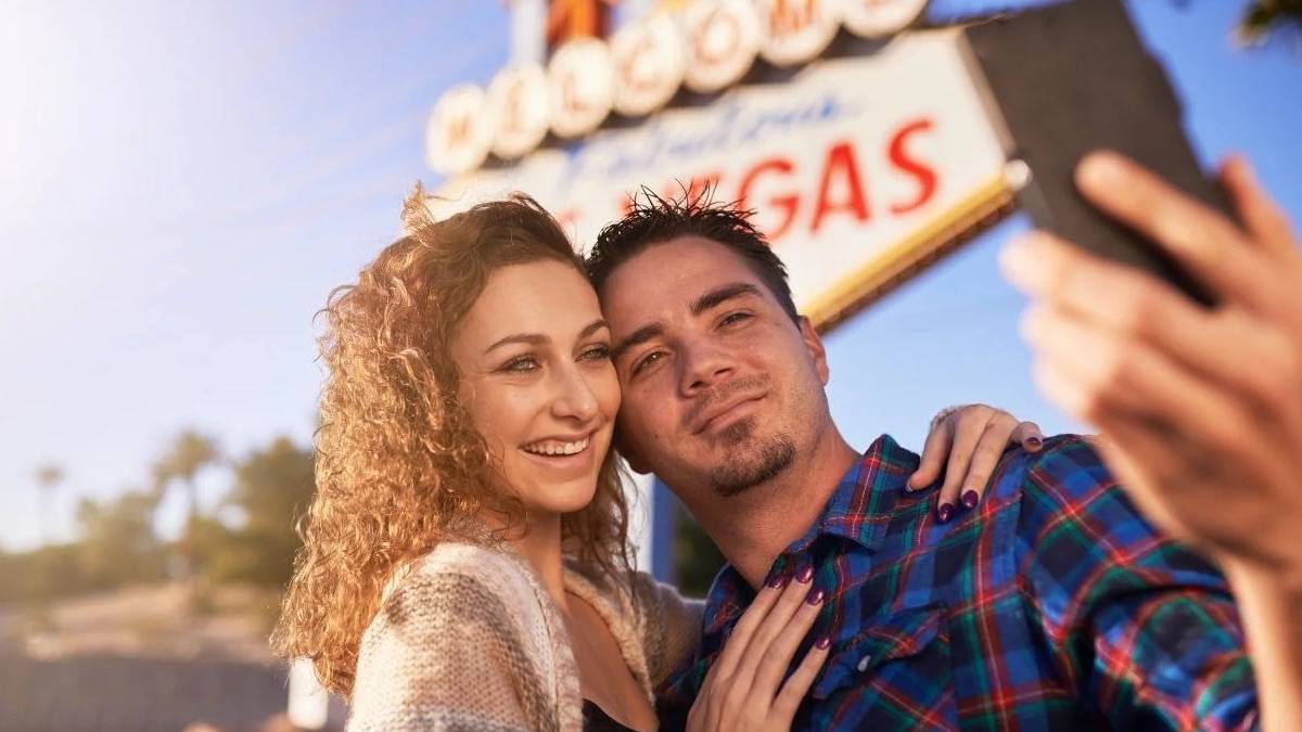 Couple taking a selfie in front of the "Welcome to Las Vegas" sign