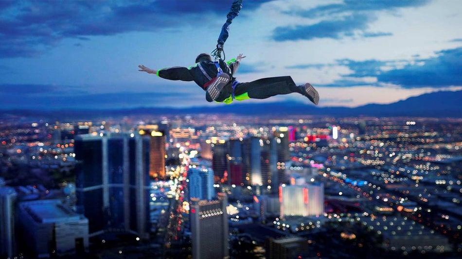 View of someone in the air after the have jumped the SkyJump at The Strat with the city of Las Vegas under them in the back ground at twilight in Las Vegas, Nevada, USA