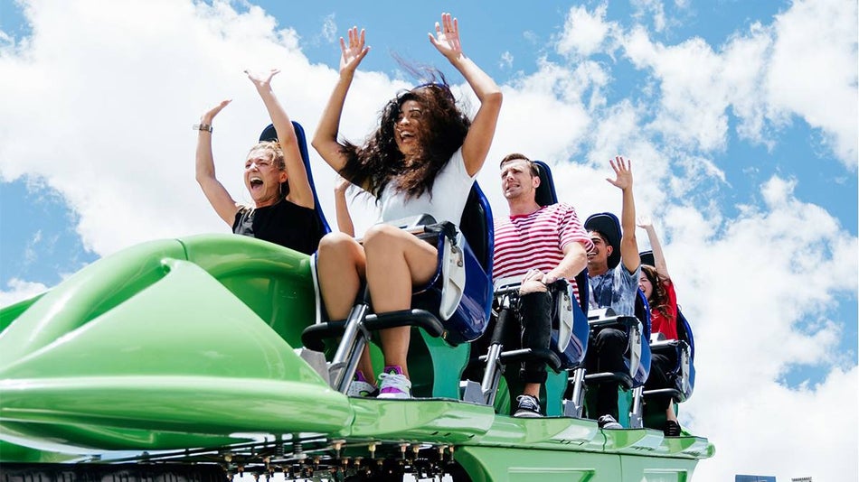 People excited riding the X Scream at the Skypod at the STRATS in the daytime with a blue cloudy sky in Las Vegas, Nevada