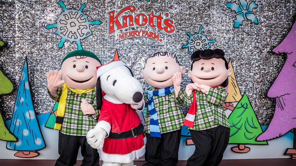 The peanuts in their Christmas outfits and snoopy dressed as Santa standing in front of the Knott's Merry Farm backdrop in Los Angeles, California, USA