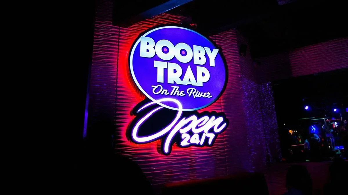 Close up of the sign for Booby Trap on the River night, blue and red glowing in the dark in Miami, Florida, USA