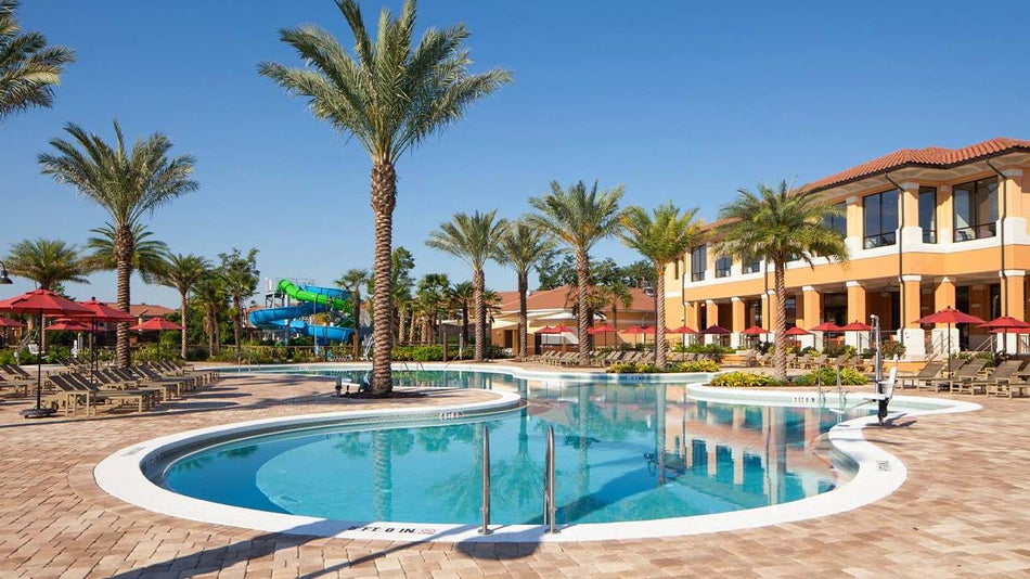 A bright blue pool with the Regal Oaks behind it and a water slides in the background