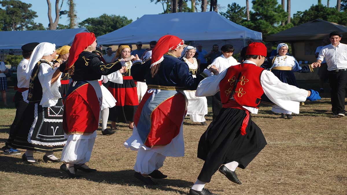 Dancers in traditional red, black, and white clothing dancing during the St. John's Greek Festival in Myrtle Beach, SC, USA