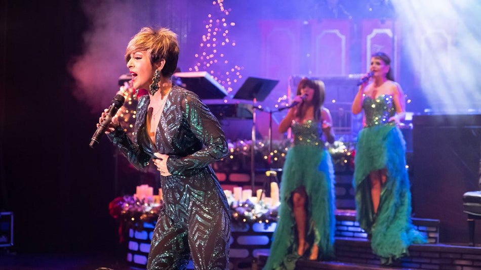 Singers and performers on stage in green costumes at the Carolina Opry Christmas Special in Myrtle Beach, South Carolina, USA.