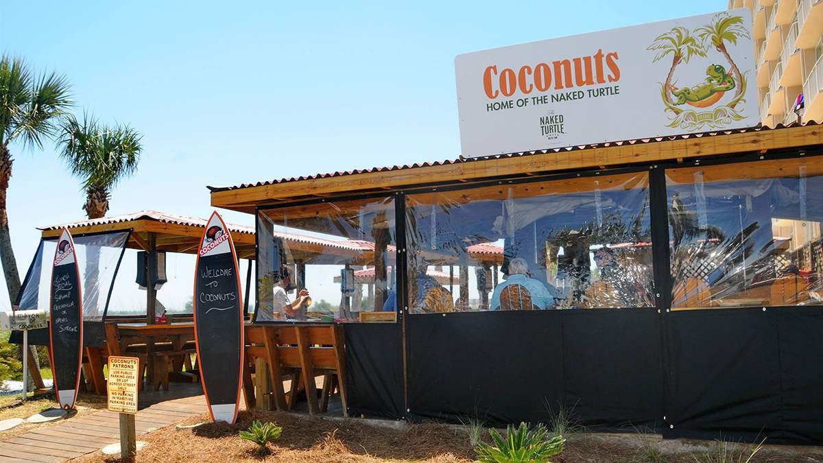 exterior ground view of Coconuts Tiki Bar with palm trees in Myrtle Beach, South Carolina, USA