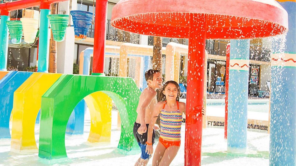 kids running through colorful water sprinklers at The Caravelle Resort in Myrtle Beach, South Carolina, USA