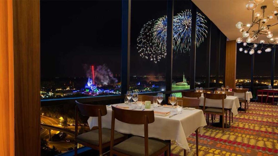 Close up of a table next to the windows at California Grill in Disney’s Contemporary Resort at night with fireworks in Orlando, Florida, USA