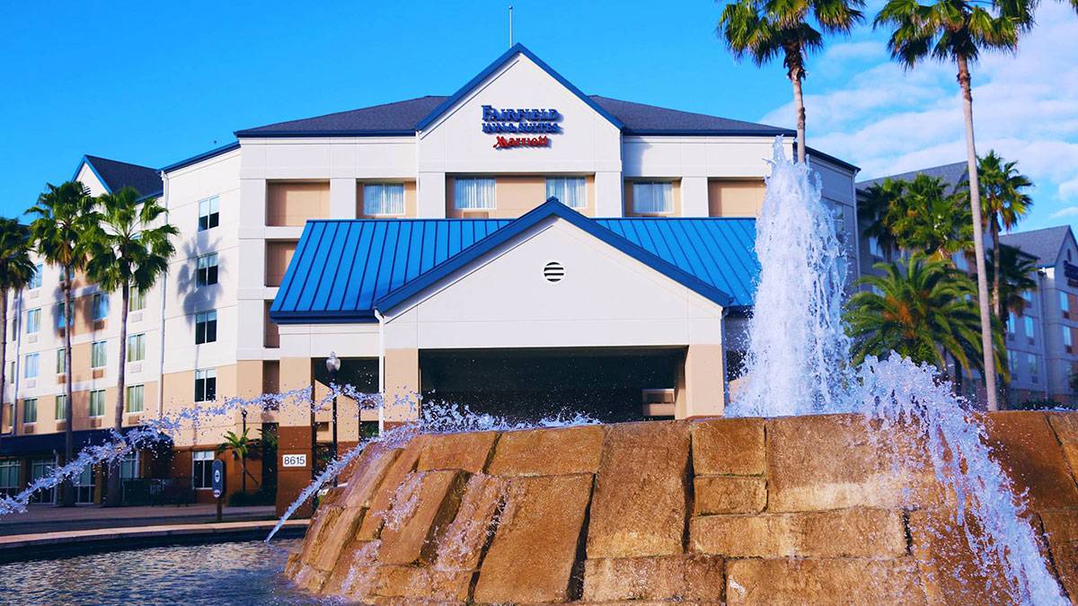 exterior of Fairfield Inn & Suites by Marriott Orlando Lake Buena Vista in the Marriott Village with palm trees and fountain in foreground in Orlando, Florida, USA