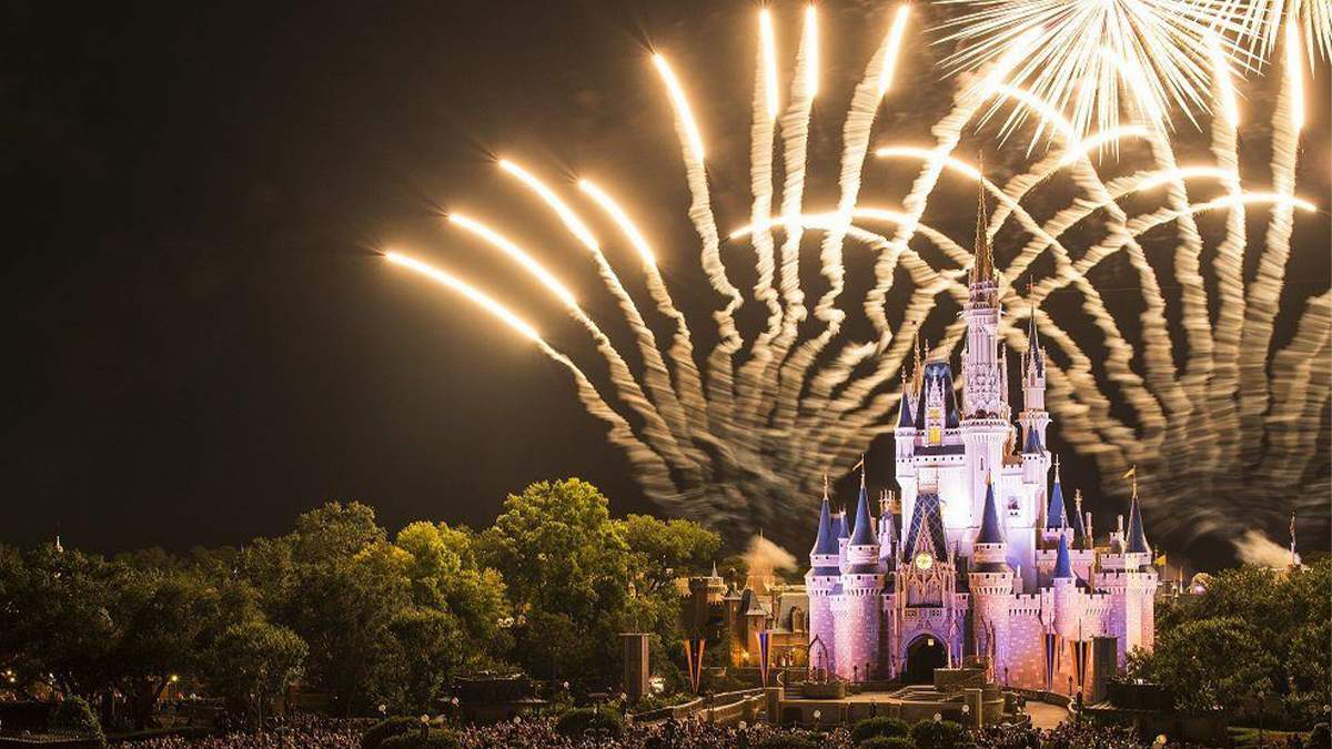 bright yellow fireworks shooting over the Walt Disney World Cinderella Castle in Orlando, Florida, USA