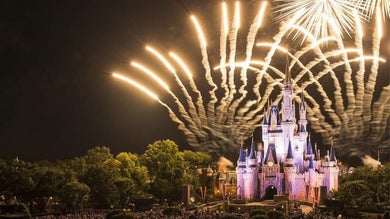 bright yellow fireworks shooting over the Walt Disney World Cinderella Castle in Orlando, Florida, USA